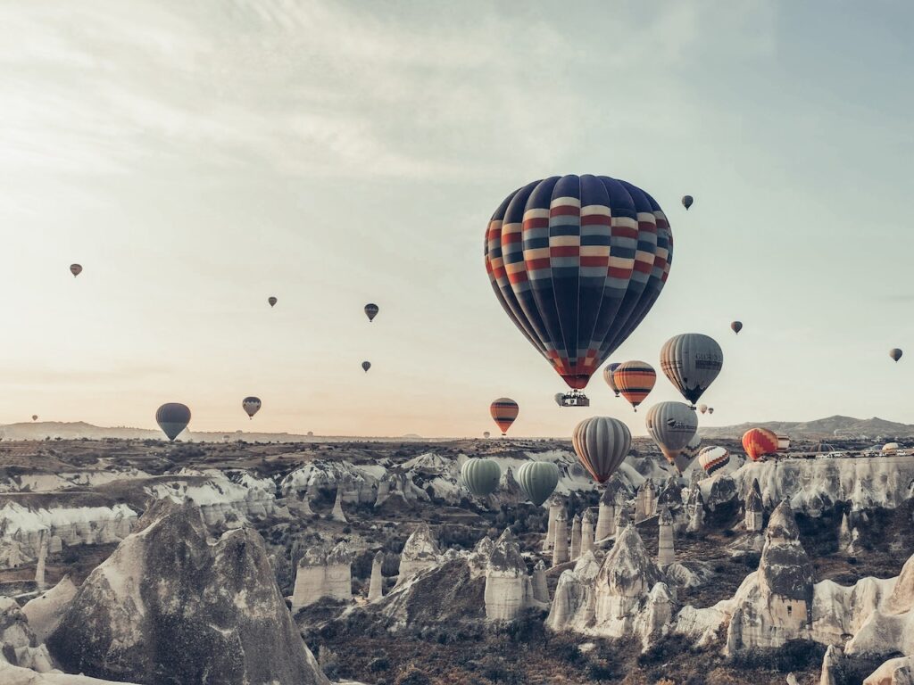 Photo by Mehmet Turgut  Kirkgoz : https://www.pexels.com/photo/colorful-air-balloons-flying-over-picturesque-rocky-terrain-5865634/